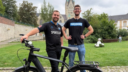 Erik Meyer und Marek Schnelle stehen vor ihrem Fahrrad.