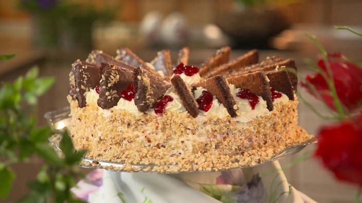 Die Nuss-Preiselbeer-Torte auf einem Plattenteller.