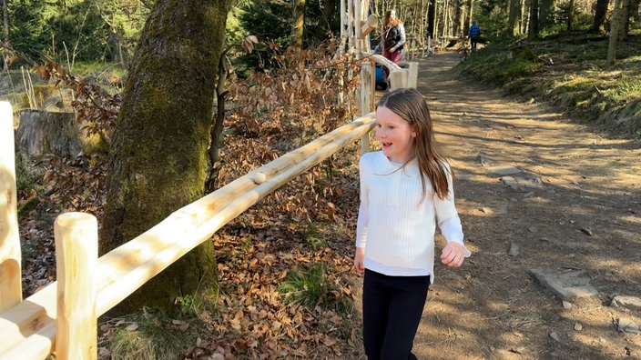 Kinder spielen an einer Kugelbahn aus Holz