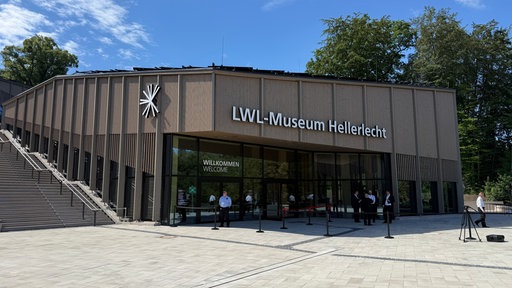Eine Gruppe von Personen vor dem Eingang eines Museums.