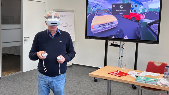 Ein Mann hat eine VR-Brille auf und bedient Controller