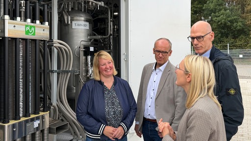 Die Geschäftsführer der Stadtwerke Bielefeld stehen vor der Wasserstofftankstelle