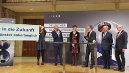 Menschen auf dem Podium bei der Preisverleihung des Nachhaltigkeistpreises im historischen Rathaus Münster
