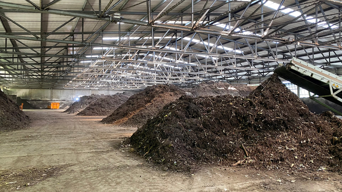 Mehrere Haufen Biomasse in einer Lagerhalle
