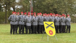 Eine Gruppe Soldaten posiert vor einer Flagge