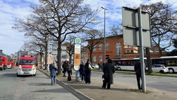 Fahrgäste warten an einer Bushaltestelle auf Ersatzbusse.
