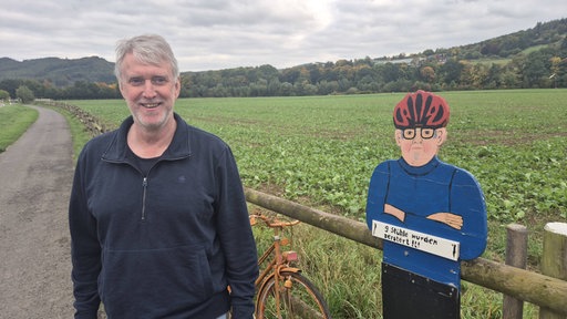 Olaf Köster, gelernter Schreiner, steht am Zaun neben dem Ruhrtal-Radweg in Arnsberg-Oeventrop