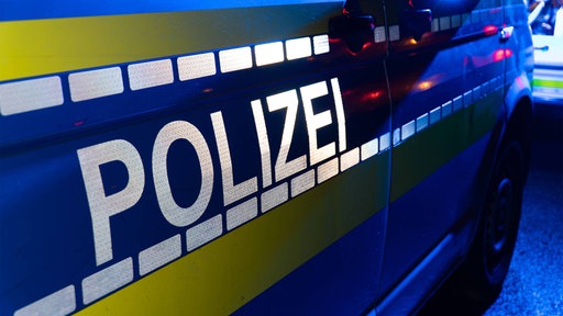 Auf der Seite eines Bullis steht der reflektierende Schriftzug "Polizei"