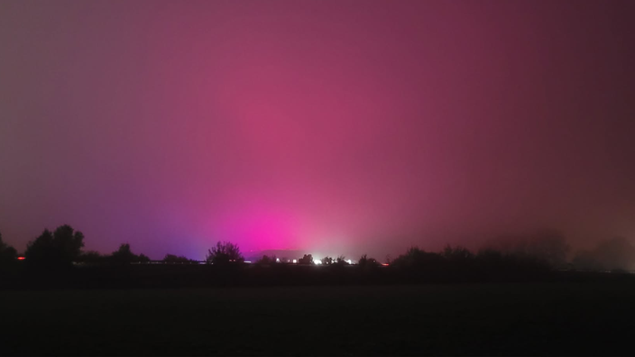 Ein pinkleuchtender Himmel bei Nacht. 