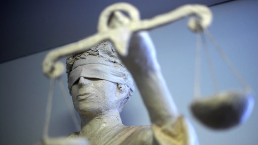 Die Statue Justitia ist in einem Gericht zu sehen.