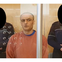 Der Angeklagte steht im Gerichtssaal. Links und rechts hinter ihm stehen zwei Justizbeamte zur Bewachung.