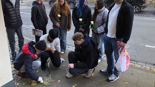Schülerinnen und schüler reinigen Stolpersteine