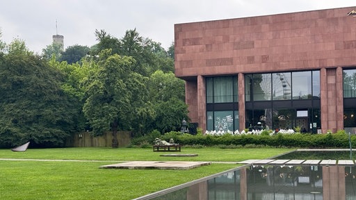 Skulpturen stehen im Vordegrund des Gartens der Kunsthalle Bielefeld, die im Hintergrund zu sehen ist