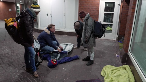 Einer Obdachlosen wird ein shelter suit erklärt
