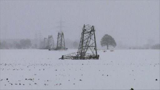 Abgebrochene Strommäste liegen im Schnee 