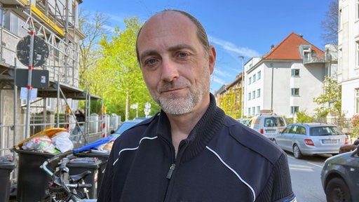 Ordnungsbeamtler Sascha Bischof steht vor einer Reihe Schrotträder.