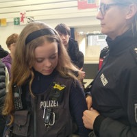 Schülerin probiert eine Polizeiuniform an