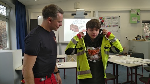 Schüler probiert Einsatzkleidung des Rettungsdienstes an