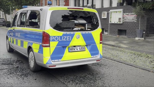 Eingeschlagene Fensterscheiben des Polizeiwagens