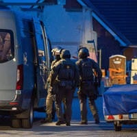 3 Beamte des SEK stehen um einen Sprinter
