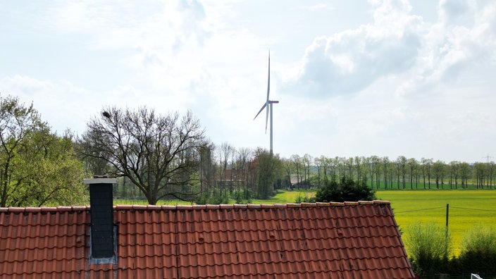 Eine Windrad steht in Sichtweite eines privaten Wohnhauses
