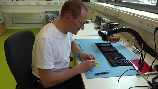 Ein Mann am Schreibtisch der das Gerät für die Mondmission entwickelt.