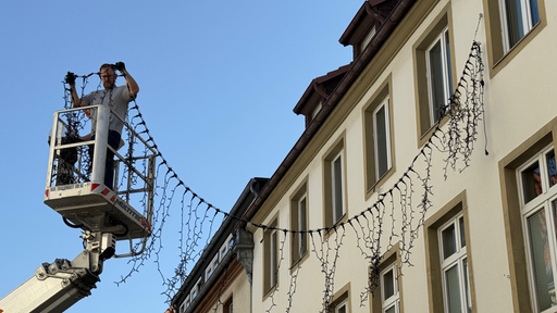 Weihnachtsbeleuchtung hängt bei blauem Himmel in der Stadt Soest.