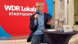 Ein Mann spricht in ein Mikrofon