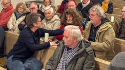 Menschen sitzen in einer Kirche