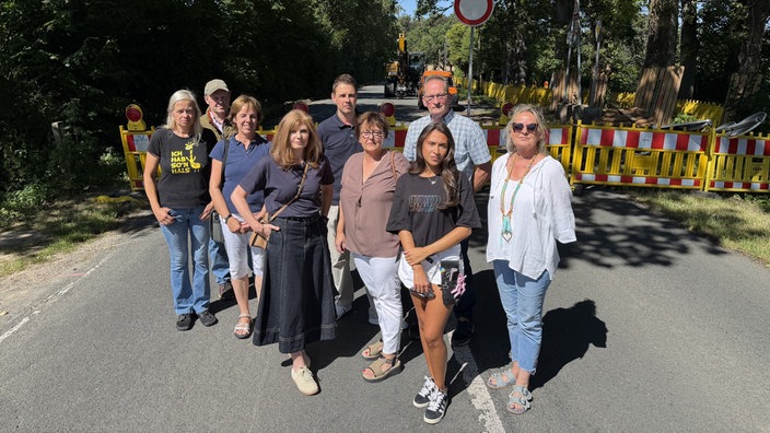 Die Unternehmer und Anwohner beunruhigt posierend vor der Baustelle.