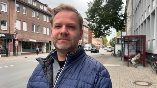 Ein Mann steht an einer Straße