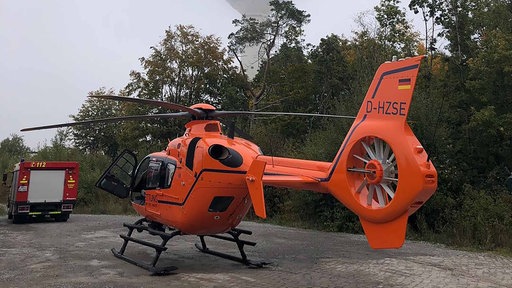 Ein Helikopter und ein Feuerwehrfahrzeug im Wald