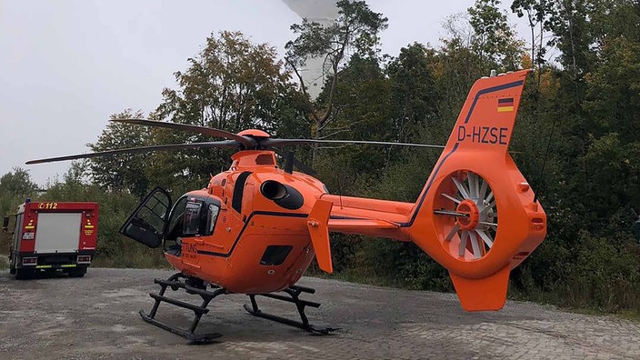 Ein Helikopter und ein Feuerwehrfahrzeug im Wald