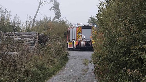 Ein Feuerwehrfahrzeug auf einem Waldweg
