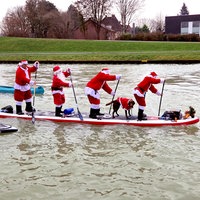 Fünf Stand-Up-Paddler in Weihnachtsmannkostümen auf dem Dortmund-Ems-Kanal