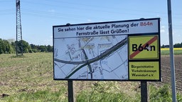Schild vor Acker mit Straßenkarte