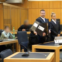 In einem Gerichtssaal sitzen mehrere Angeklagte und Juristen 