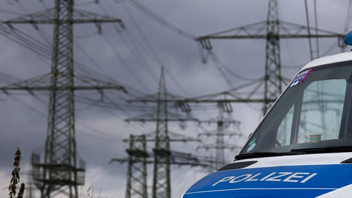 Polizeifahrzeuge stehen in der Nähe des RWE-Kraftwerkes Eschweiler an einem Umspannwerk. 