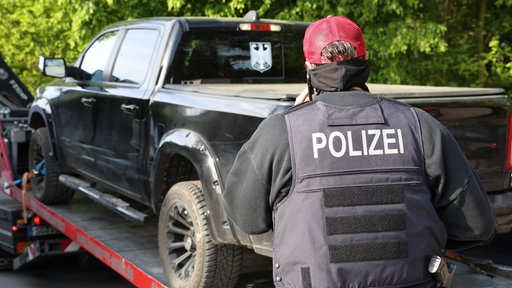 Polizist vor einem großen Auto