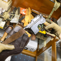 Waffe wird aus Leder- Holster gezogen, Hände mit Arbeitshandschuhen