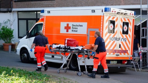 Rettungskräfte bereiten wegen der hohen Temperaturen im Gebäude die Evakuierung von Bewohnerinnen und Bewohnern eines Seniorenheims vor.