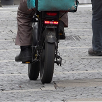 Ein Lieferfahrer auf einem motorisierten Bike auf der Straße