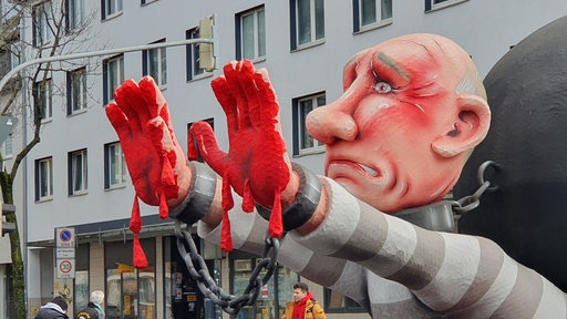 Ein Karnevalswagen mit Putin-Figur, die Blut an den Händen hat