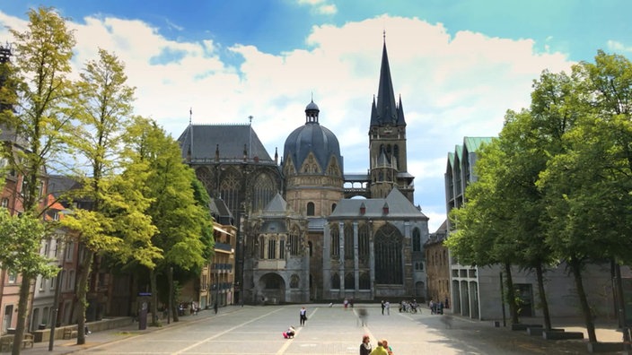 Der Aachener Dom, im Vordegrund ein Platz mit Menschen