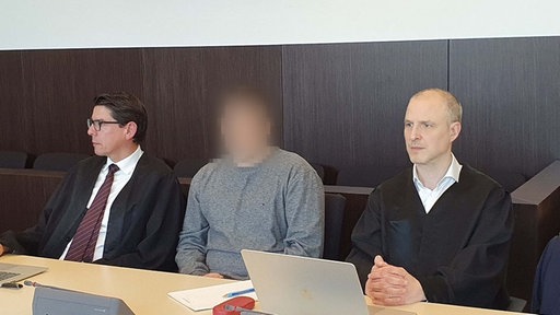 Zwei Anwälte und ein Angeklagter im Gericht