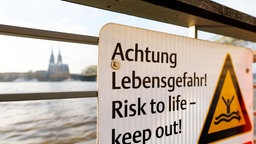 Warnschild, im Hintergrund der Kölner Dom