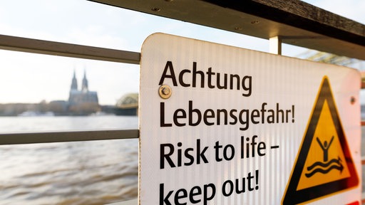 Warnschild, im Hintergrund der Kölner Dom