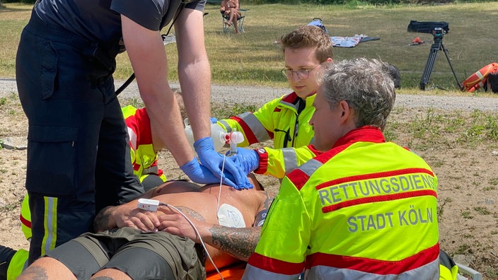 Das Bild zeigt Rettungskräfte die Erste Hilfe leisten.