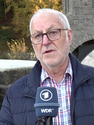 Bagger und Baufahrzeige am Ufer der Agger.
