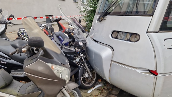 Der Zugteil der Bahn zerdrückt zwei Roller.